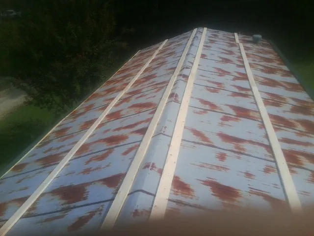 Rusted metal roof panels with new wood purlins before replacement — Storm Damage Roof Repair in Gasburg by Roofing Brothers